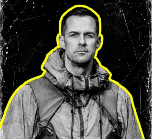 Adam Beyer in a technical jacket, photographed in black and white with a yellow outline.
