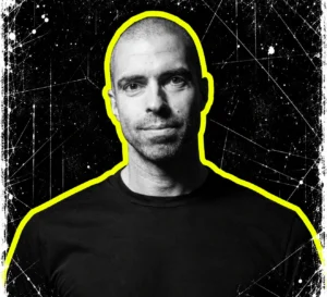 Chris Liebing in a black T-shirt, in a grayscale portrait with a bright yellow cutout outline.
