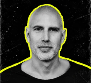 Daniel Bell, also known as DBX, in a black-and-white head-and-shoulders portrait with a yellow outline.