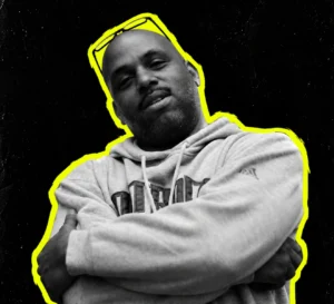Eddie Fowlkes wearing a hoodie with arms folded, in black and white with a yellow outline.