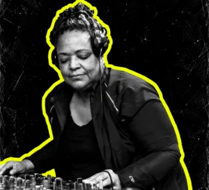 K-Hand DJing at a mixer, pictured in black and white with a bright yellow outline.