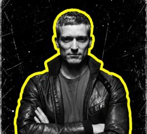Ben Klock with folded arms and a leather jacket, in a black-and-white portrait outlined in yellow.