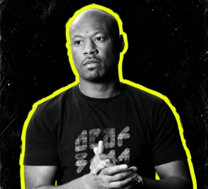 Robert Hood with hands clasped, in a black-and-white portrait outlined in yellow.